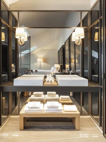 a bathroom with two sinks and two mirrors at Casa da Companhia Hotel & Spa, Vignette Collection by IHG in Porto
