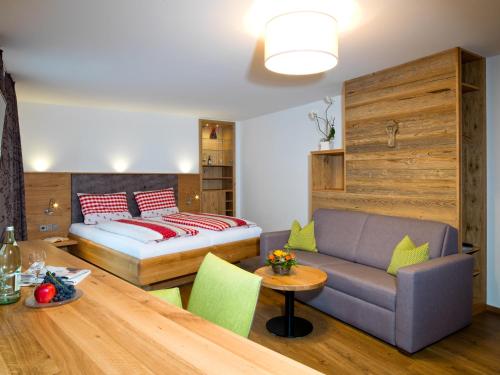 ein Wohnzimmer mit einem Sofa und einem Bett in der Unterkunft Landgasthof Lusenblick in Grafenau