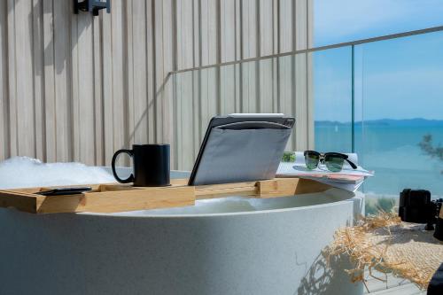 a desk with a laptop computer on top of it at Bayphere Hotel Pattaya JC in Na Jomtien