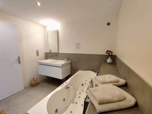 a bathroom with a bath tub and a sink at Les Digues Vauban in Ciboure