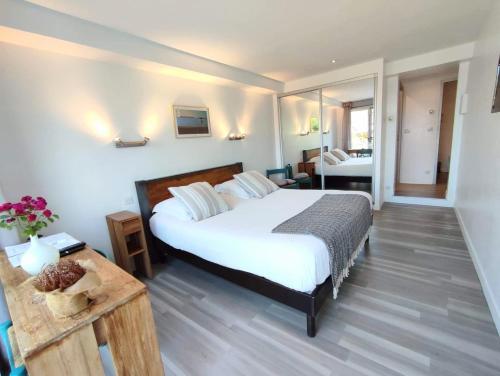 a bedroom with a large white bed and a table at Les Digues Vauban in Ciboure