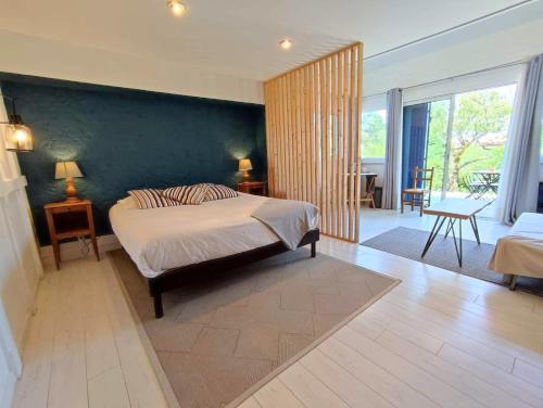 a bedroom with a bed and a green wall at Les Digues Vauban in Ciboure