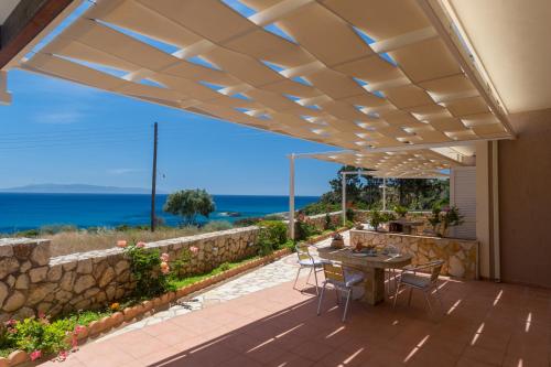 a patio with a table and chairs and the ocean at Asta La Vista Maisonettes in Pesádha