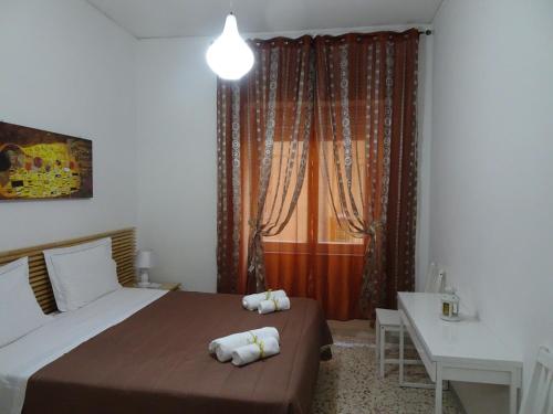 Schlafzimmer mit einem Bett, einem Schreibtisch und einem Fenster in der Unterkunft B&B DODO in Salerno