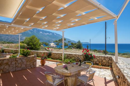 a patio with a table and chairs and a view of the ocean at Asta La Vista Maisonettes in Pesádha
