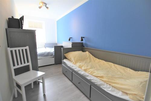 ein Schlafzimmer mit einem Bett und einem Stuhl darin in der Unterkunft Nordspitze in Cuxhaven