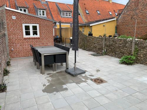 a patio with a table and chairs and a fence at Præstegade 11 in Ribe