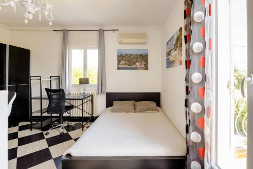 - une petite chambre avec un lit et un bureau dans l'établissement Villa Les Lauriers, à Antibes