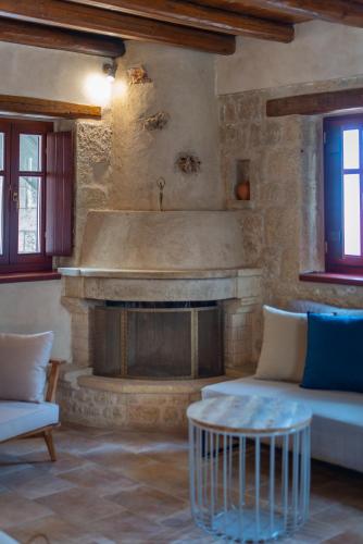 a living room with a stone fireplace and a couch at Brazzo di Maina in Oítilon
