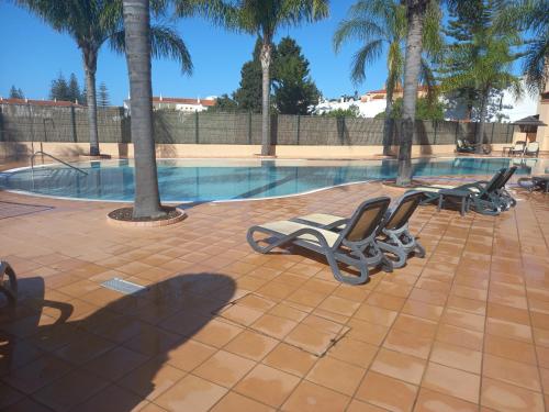 a group of lounge chairs next to a swimming pool at La Suite Calypso in Luz