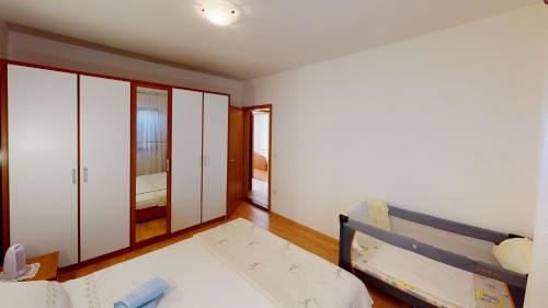 a bedroom with white cabinets and a bed in it at Big Pag apartament close to Zrće beach in Metajna