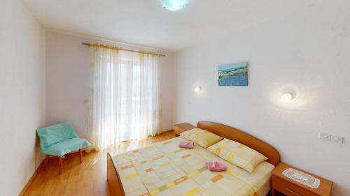 a bedroom with a bed and a blue chair at Big Pag apartament close to Zrće beach in Metajna
