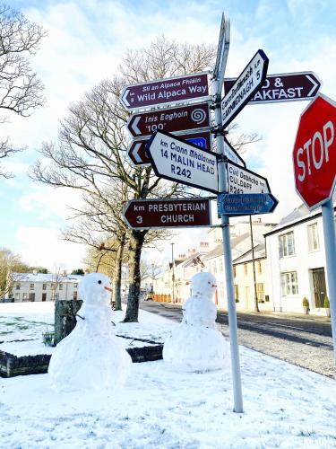 two snowmen are standing next to a stop sign at Malin TownHouse in Malin