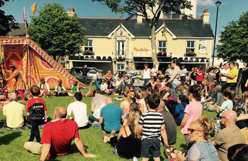 a crowd of people sitting on the grass in front of a tent at Malin TownHouse in Malin