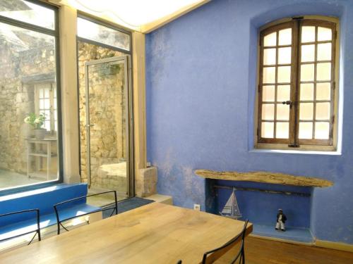 ein blaues Zimmer mit einem Holztisch und einem Kamin in der Unterkunft Appartement au coeur du village- Ref12 in Saint-Paul-Trois-Châteaux