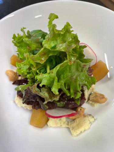 a white plate of food with lettuce and potatoes at Loch Lein Country House in Killarney