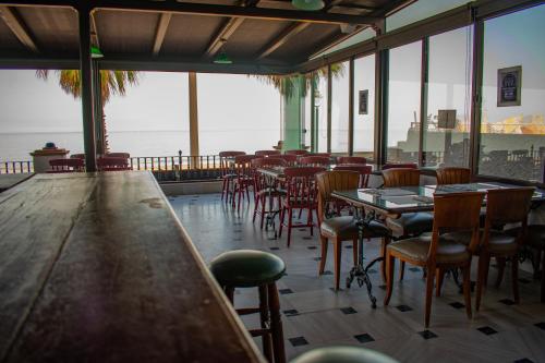 a restaurant with tables and chairs and a view of the ocean at Hotel Playa de Regla in Chipiona