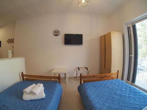 a bedroom with two beds and a tv on the wall at Bettys rooms in Paralion astros