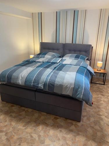 a bed with a blue and white comforter in a bedroom at Apartment Häuserstraße 15 in Northeim