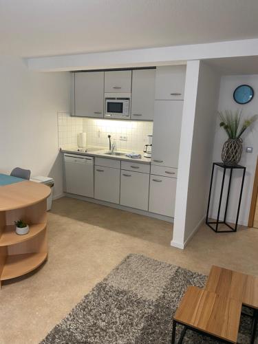 a kitchen with white cabinets and a table at Apartment Häuserstraße 15 in Northeim