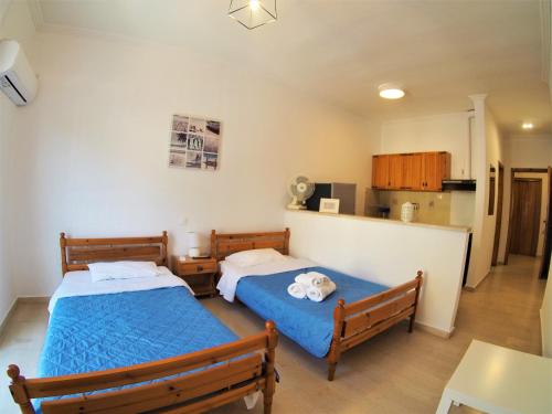 a bedroom with two beds and a kitchen at Bettys rooms in Paralion astros