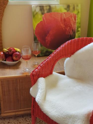 a table with two glasses of wine and a bowl of fruit at THE POPPIES Guest House - 100m Ocean - Private Spaces in Candelaria