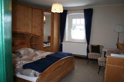 a bedroom with a bed and a chair and a window at Isi-Hof 