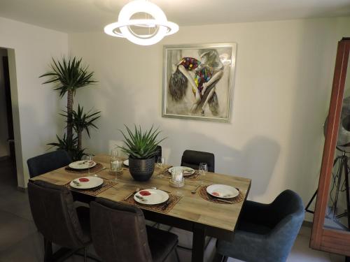 a dining room table with chairs and a painting on the wall at Mallo's Lodge avec Parking GRATUIT et 2 balcons in Colmar