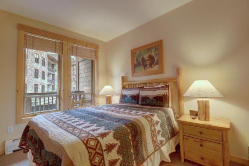 a bedroom with a bed and two lamps and a window at Tx212 Taylors Crossing Condo in Copper Mountain