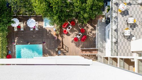 een uitzicht over een zwembad met rode ligstoelen bij Hotel Rainbow ***S in Rimini