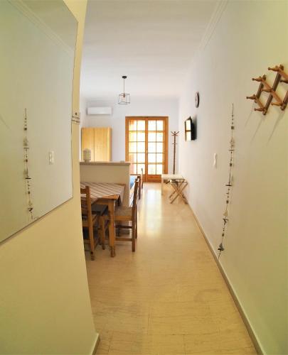 a hallway leading to a dining room and kitchen with a table at Bettys rooms in Paralion astros