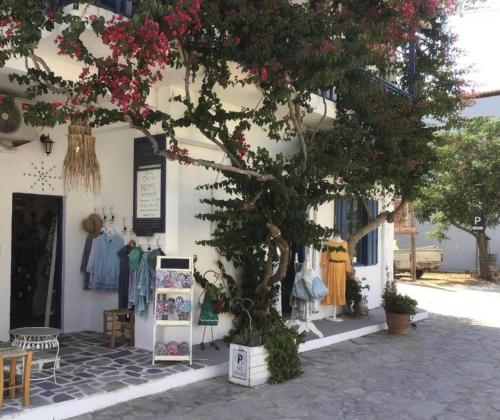 a shop with a tree in front of a building at Chez Cécile Home in Mochlos