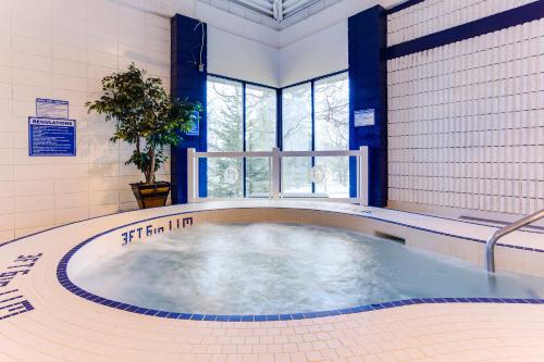 a large hot tub in a room with a window at Park Town Hotel in Saskatoon