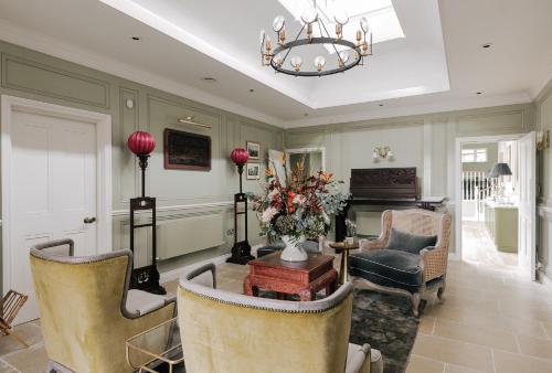 a living room with chairs and a table and a piano at Tyndall Villa Boutique B&B in Bath