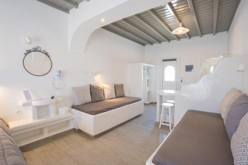 a room with a bed and a sink and a mirror at Zisis Pension in Agios Stefanos
