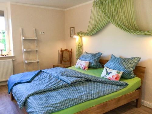 Schlafzimmer mit einem Bett mit blauer Bettwäsche und Kissen in der Unterkunft Ferienwohnung Schubertstraße in Malchow