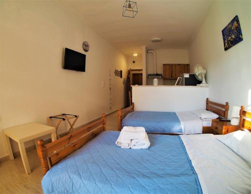 two beds in a room with blue and white at Bettys rooms in Paralion astros