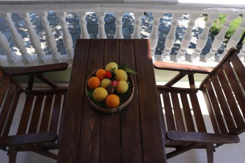 un bol de fruta sentado sobre dos sillas en Nerajoula House, en Parga