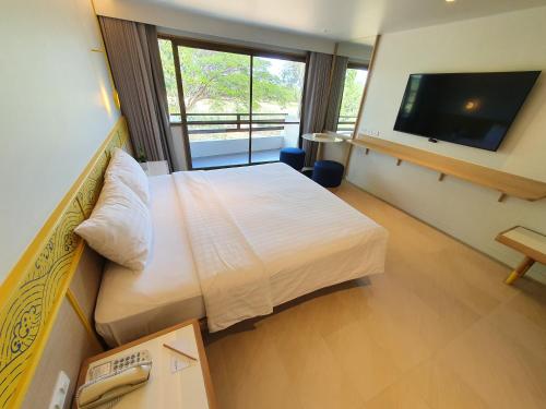 a hotel room with a large bed and a television at Novotel Rayong Rim Pae Resort in Klaeng