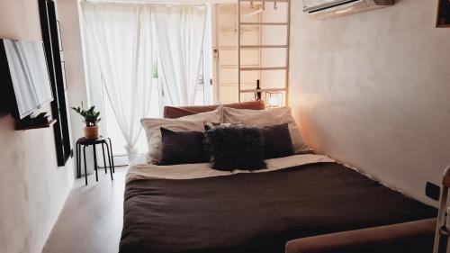 una camera da letto con un grande letto con cuscini sopra di Casa nostra Capodistria a Capodistria