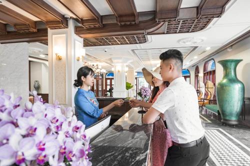 a group of people standing at a counter in a train at Grand Fleuve Boutique in Ha Long