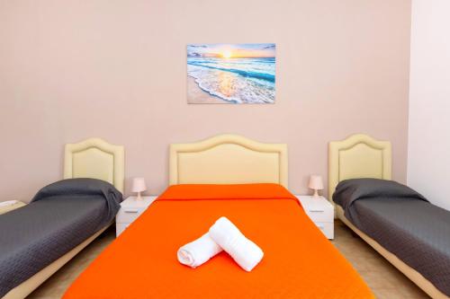 a bedroom with two twin beds with orange sheets at Sisters Hotel in Piano di Sorrento
