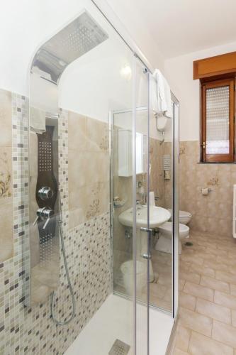 a bathroom with a shower with a sink and a toilet at Sisters Hotel in Piano di Sorrento
