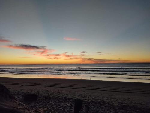 a sunset on a beach with the ocean at Navega Beach Palace Hotel in Navegantes