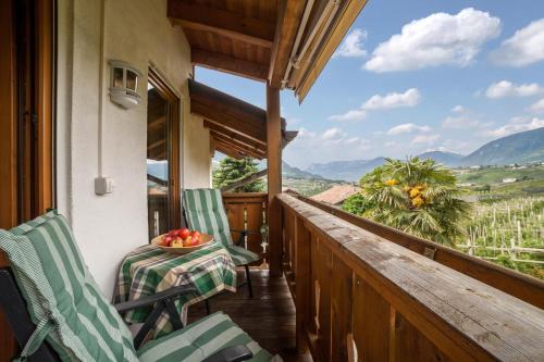 a balcony with chairs and a bowl of fruit on a table at Langeshof Fewo Morgensonne in Caines