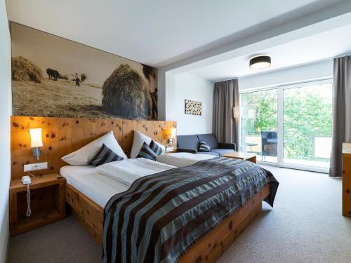 pokój hotelowy z łóżkiem i kanapą w obiekcie Hotel Streklhof w mieście Velden am Wörthersee
