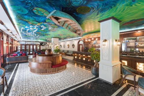 a hotel lobby with a colorful ceiling and a bar at Grand Fleuve Boutique in Ha Long