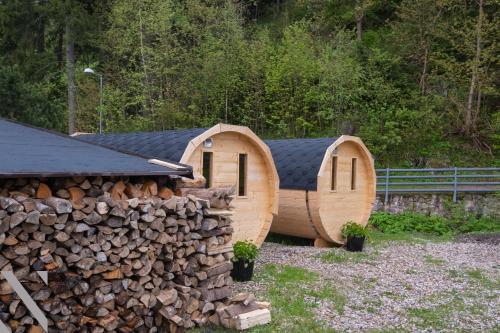 ein rundes Holzhaus mit einem Stapel Holz in der Unterkunft Hotel Hvezda in Pec pod Sněžkou