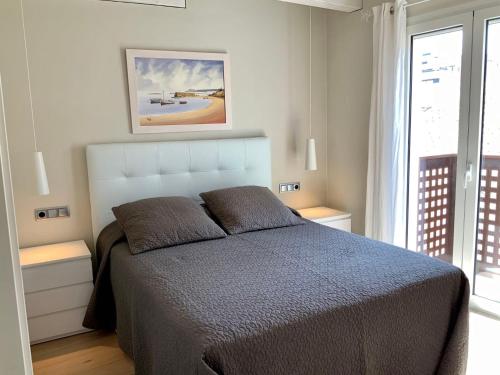 1 dormitorio con cama y ventana grande en Dúplex Can Quim, Terrace Boutique Apartment, en L'Escala
