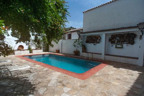 a swimming pool in a yard next to a house at La casa de la abuela Regina in Grazalema